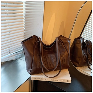 Dettaglio della borsa tote in ecopelle marrone scuro con goffratura PINKBAG e doppi manici