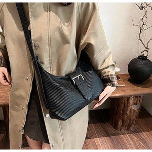 Close-up of black pleated crescent bag featuring silver buckle and rich leather texture