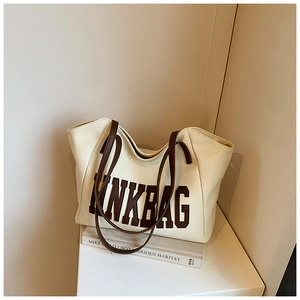Dettaglio della borsa tote crema con tracolla marrone a contrasto e stampa INKBAG