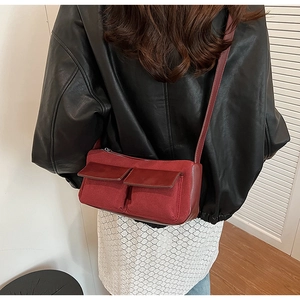 Model wearing dark red bowling bag with dual front pockets and adjustable strap