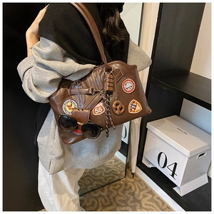 Detailansicht der dunkelbraunen Retro-Ledertasche mit Vintage-Stickerei-Patches