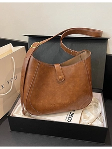 Vintage brown leather hobo bag with Pantone logo presented in a premium gift box