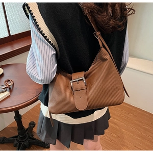 Detail of brown textured hobo bag with silver buckle and elegant pleated leather finish