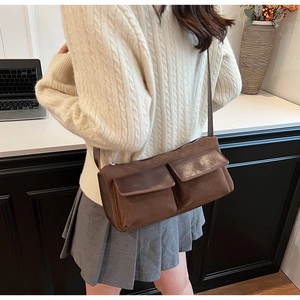 Detailed view of dark brown suede crossbody bag with two front pockets for daily commute
