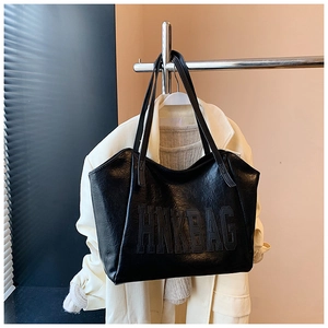 Dettaglio della borsa tote in pelle nera con logo HNK BAG e texture vintage