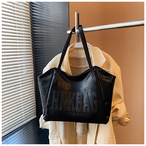 Dettaglio borsa tote in pelle nera testurizzata con goffratura HNKBAG e tracolle sottili
