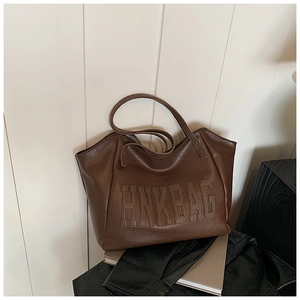 Dettaglio del logo HNKBAG sulla borsa tote grande in similpelle marrone