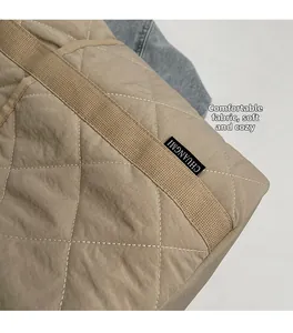 Vue macro du tissu matelassé kaki et de la bandoulière d'un grand sac cabas d'hiver