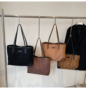 Minimalistische Wildleder-Tote-Bags in Schwarz, Hellbraun und Leopardenmuster am Ständer