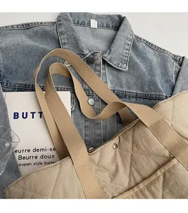 Détail d'un sac cabas matelassé kaki avec coutures blanches et large bandoulière