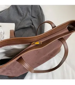 Detailaufnahme von Metall-Reißverschluss und Fischgrätenfutter der Wildledertasche