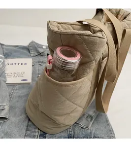 Détail de la poche latérale sur un sac cabas matelassé avec rangement pour bouteille