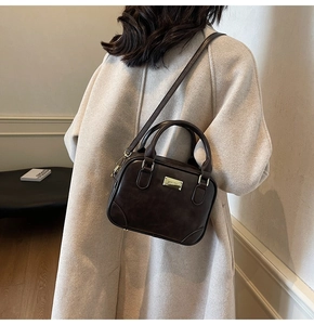 Detail of vintage coffee brown square bag with gold hardware on wool coat