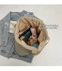 Vue macro de l'intérieur du grand sac cabas beige matelassé avec plusieurs compartiments