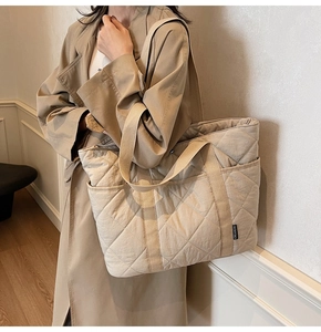 Détail du sac cabas matelassé beige montrant les losanges et les larges bandoulières