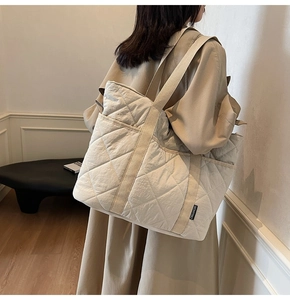 Détail du sac fourre-tout matelassé beige montrant sa grande capacité et ses motifs