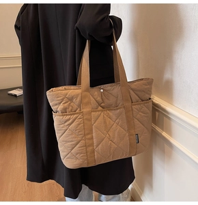 Gros plan du sac fourre-tout matelassé kaki avec motif en losange et étiquette tissée