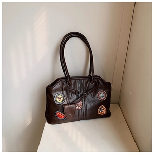 Nahaufnahme der braunen Vintage-Tasche mit Retro-Stickereien und hochwertiger Lederstruktur