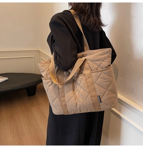 Détail du sac cabas matelassé kaki avec poche latérale et texture en nylon lisse