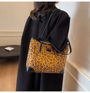 Schicke Tragetasche mit Leopardenmuster am Modell mit schwarzem Lederbesatz und Schultergurt