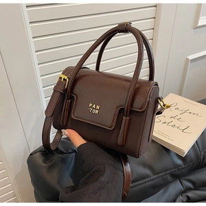 Detailed close-up of a vintage brown leather handbag with gold PAN TOR logo lettering