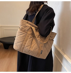 Détail du sac cabas matelassé kaki avec étiquette de marque et bandoulière rembourrée