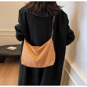 Hobo-Schultertasche aus camelfarbenem Wildleder am Model für einen natürlichen Faltenwurf