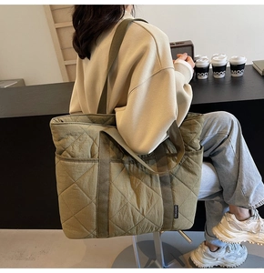 Détail du sac cabas matelassé vert olive montrant la texture en losange et l'étiquette