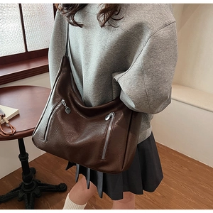 Détail du grand sac cabas en similicuir marron avec texture lisse et zips en métal
