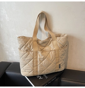 Détails du sac cabas matelassé beige avec coutures en losange et étiquette latérale