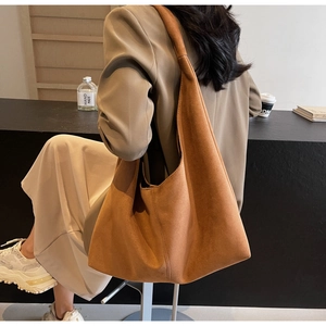 Sac fourre-tout chic en daim marron caramel dans un café pour les déplacements quotidiens
