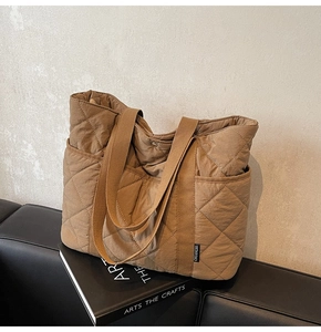 Détail du sac cabas matelassé marron montrant la poche latérale et l'étiquette CHUANGMI