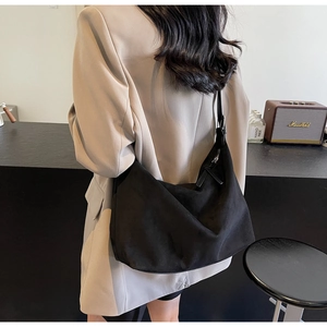 Detail einer minimalistischen schwarzen Hobo-Tasche mit verstellbarem Schultergurt