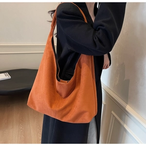 Gros plan d'un grand sac hobo en daim caramel montrant la texture et la grande capacité