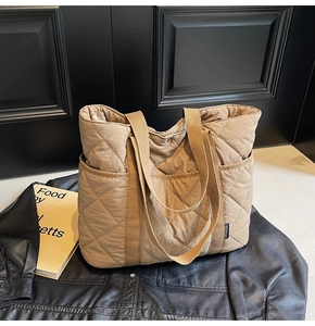 Détail du sac cabas matelassé kaki avec coutures en losanges et poche latérale sur cuir