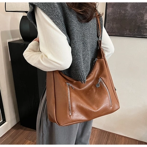 Vue portée d'un grand sac hobo marron vintage en cuir avec deux fermetures éclair