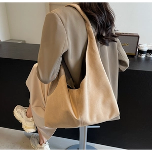 Détail du sac hobo en daim kaki avec surpiqûres contrastées sur la large bandoulière