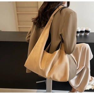 Détail d'un grand sac cabas en daim fauve avec couture verticale et large bandoulière