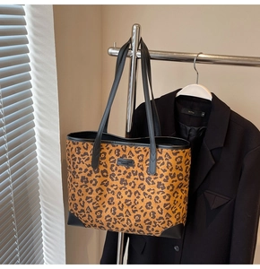 Detailansicht der Leopard-Print-Tote-Bag mit schwarzem Lederbesatz an einem Büro-Blazer