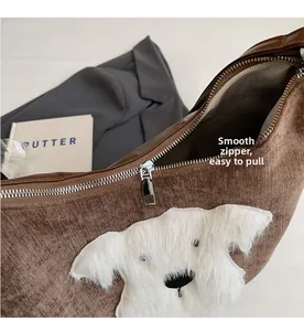 Close-up of smooth silver zipper on a brown corduroy bag with dog patch detail