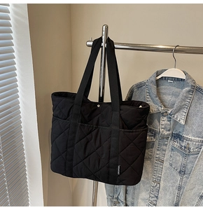 Détail du sac cabas matelassé noir en nylon avec coutures en losange et doubles poches