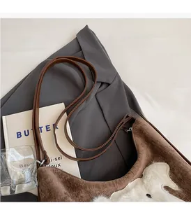 Detail of cute puppy plush patch on brown corduroy tote bag with leather straps