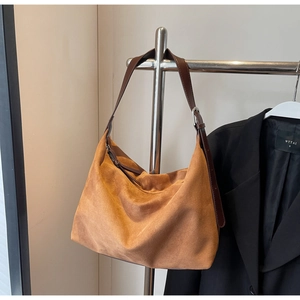 Nahaufnahme der braunen Wildledertasche mit verstellbarem Lederriemen und Metallschnalle