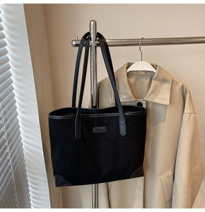 Detail der schwarzen Wildleder-Tote Bag mit verstärkten Lederecken und Marken-Logo-Patch