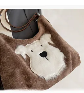 Detail of brown corduroy tote bag featuring a cute plush dog patch and leather straps