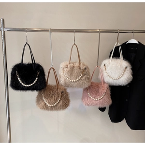 Borse a tracolla in peluche in vari colori con catene di perle su un supporto in metallo
