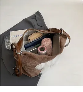 Interior view showing the large storage capacity of the brown corduroy tote with plush trim