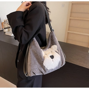 Close-up of grey suede tote bag with a white plush Schnauzer design and leather strap