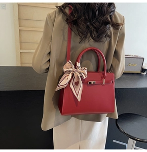 Détail du sac à main rouge de mariée avec foulard en soie à cœurs et fermoir en métal