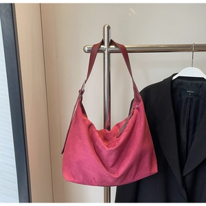 Detail der fuchsiafarbenen Wildleder-Hobo-Tasche mit Lederriemen und Silberschnalle